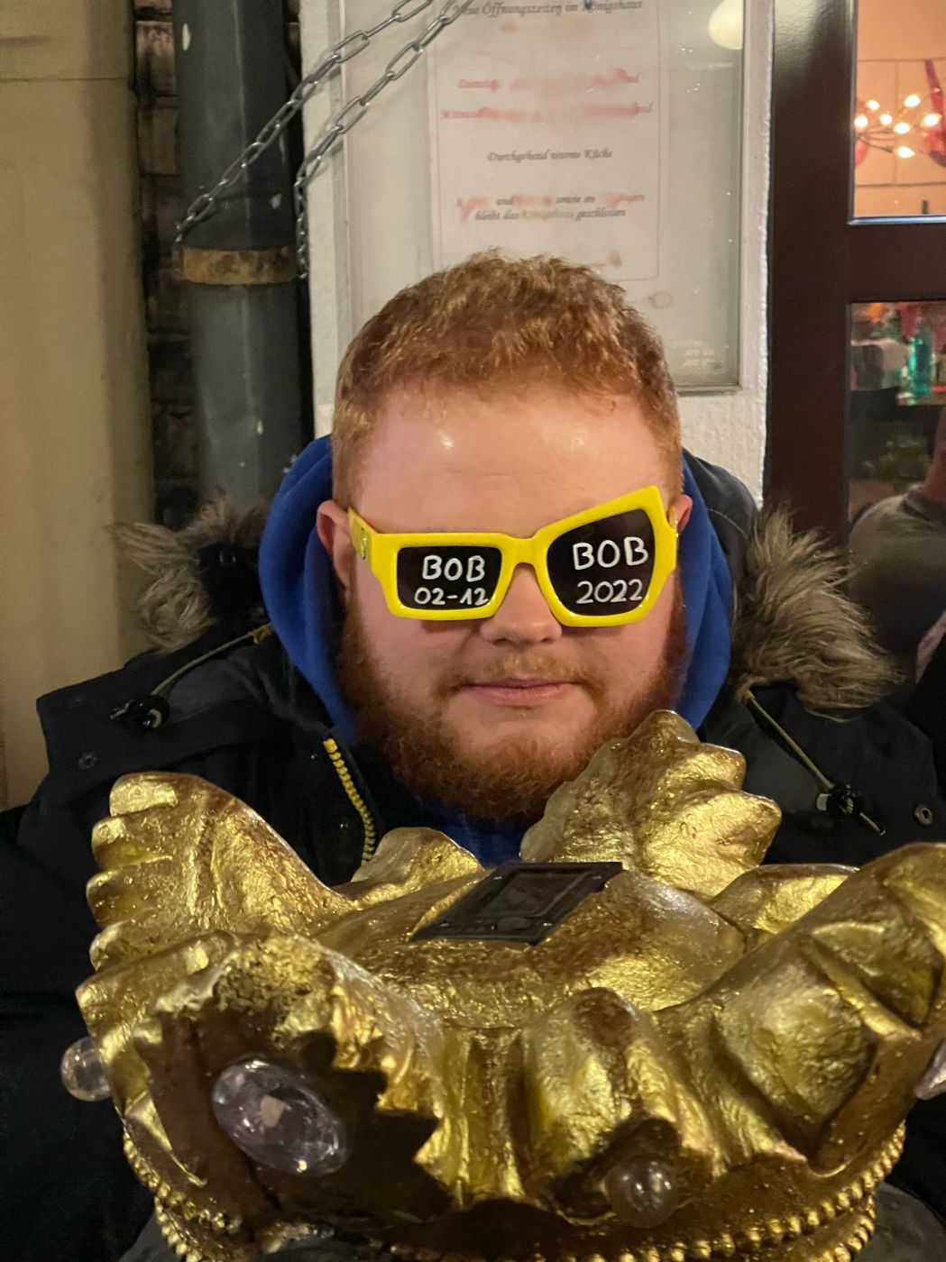 Teilnehmer mit gelber Brille hinter einer goldenen Krone